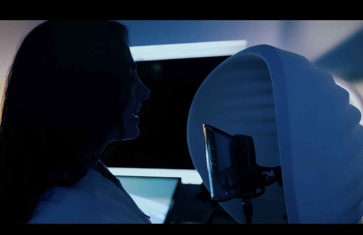 A blue-lit recording moment at the studio microphone